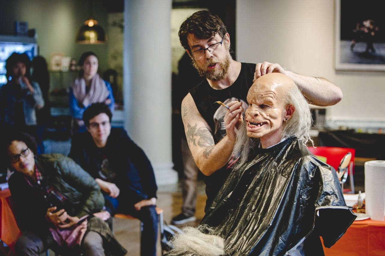 Professors Benevidas demonstrates special effects make up on a student volunteer