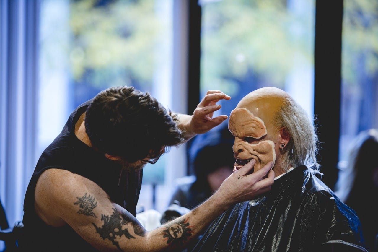 Benavides applying a foam latex mask to a model's face