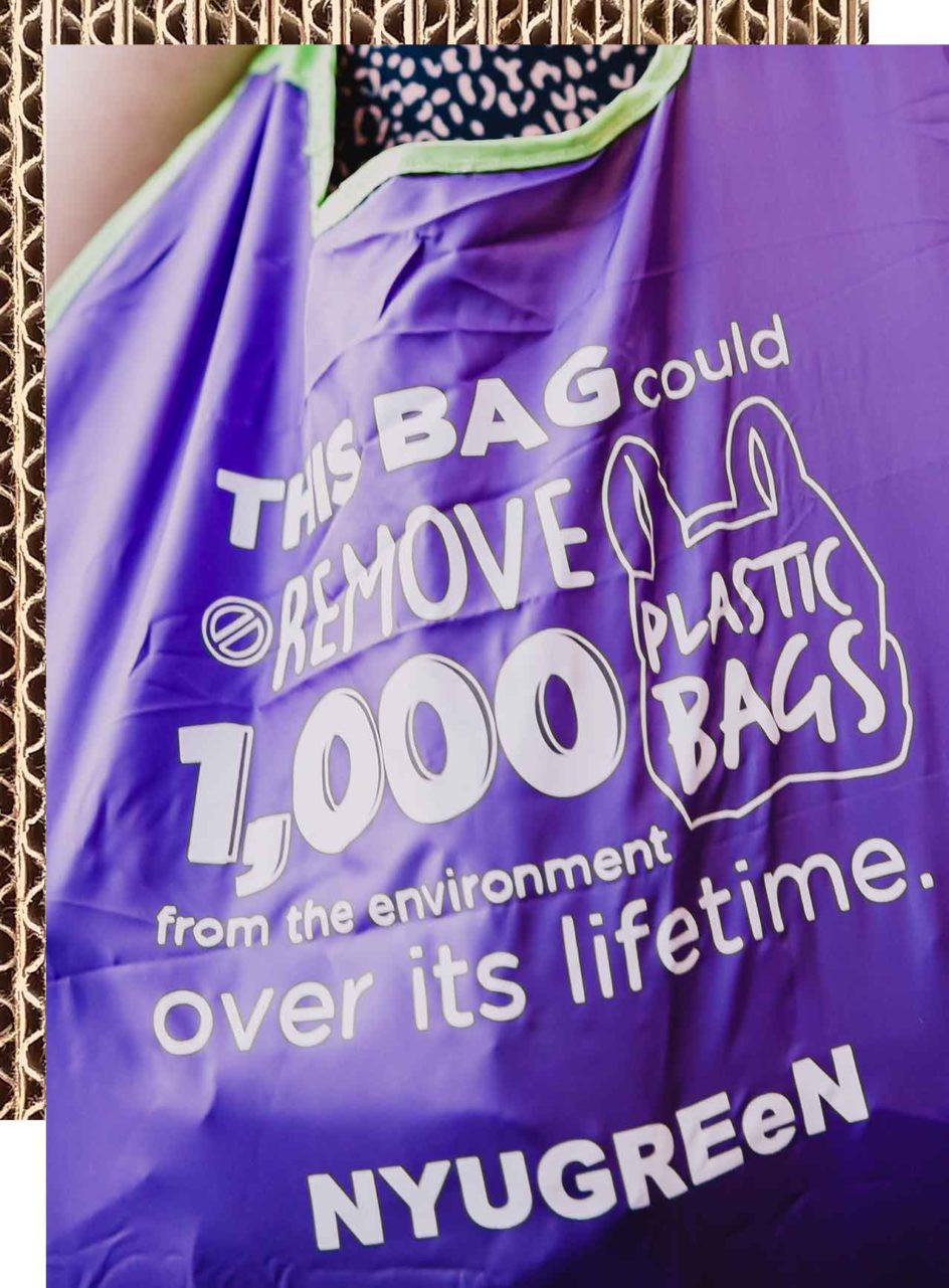 An NYU Green tote bag that says, “This bag could remove 1,000 plastic bags from the environment over its lifetime.”