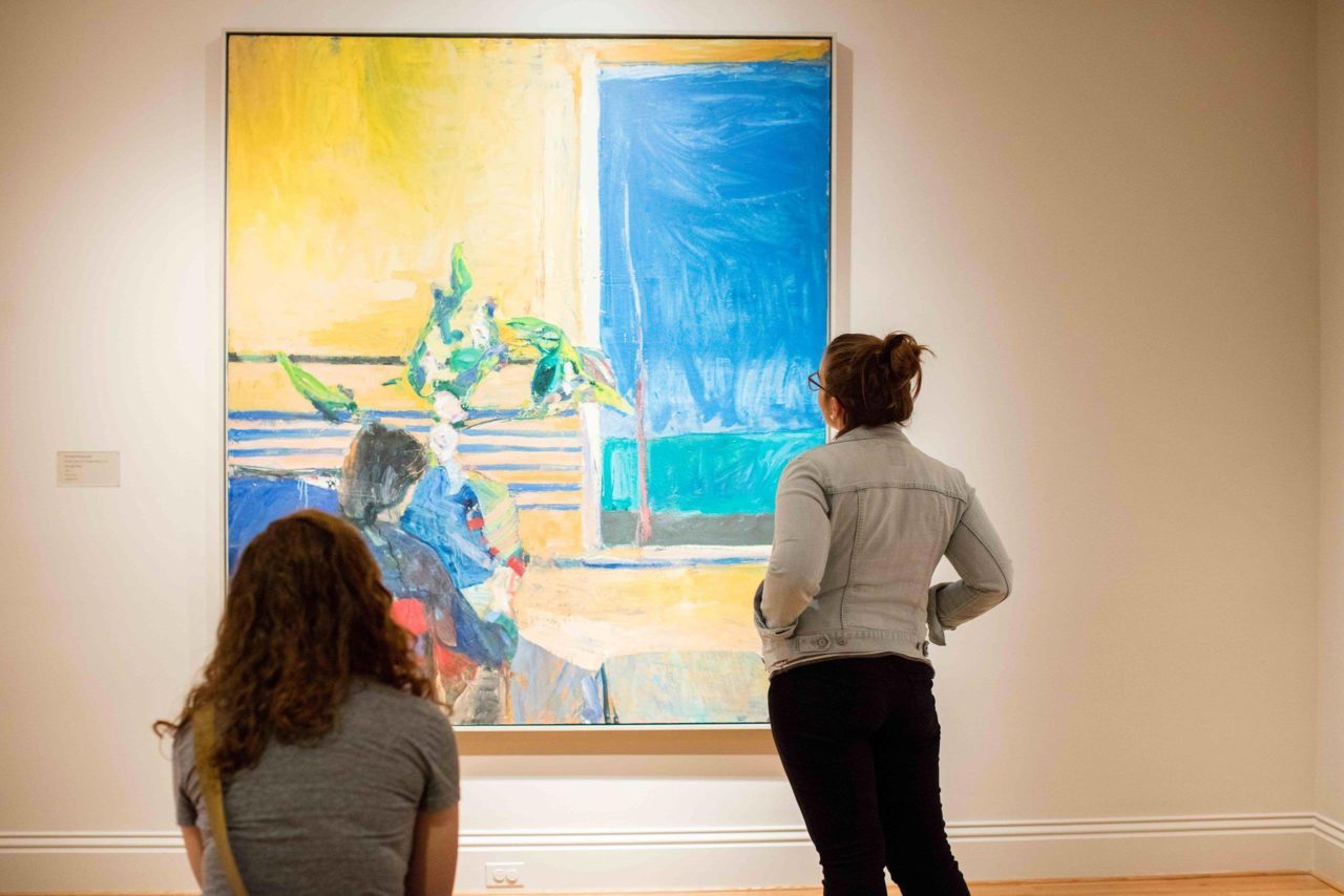 Two students look at art in a museum.