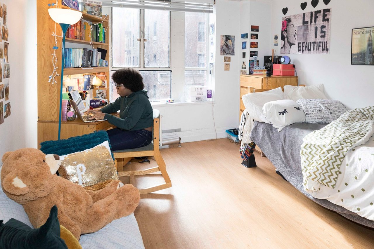 A student sits in her residence hall room.