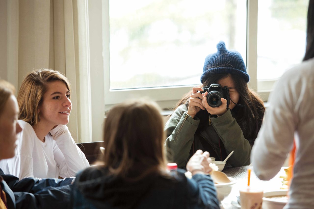 A student takes a photograph of other students.