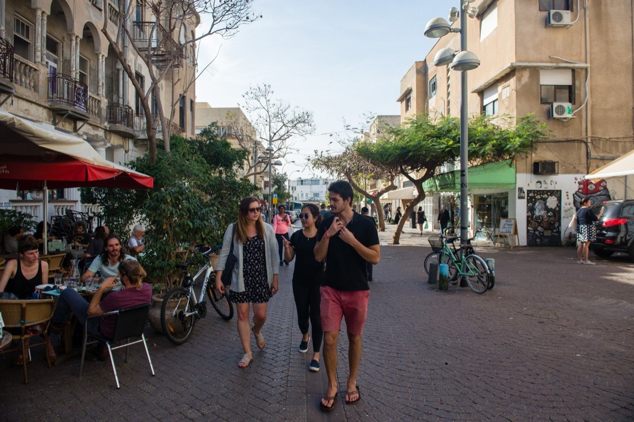 Students stroll in front of a cafe in Tel Aviv