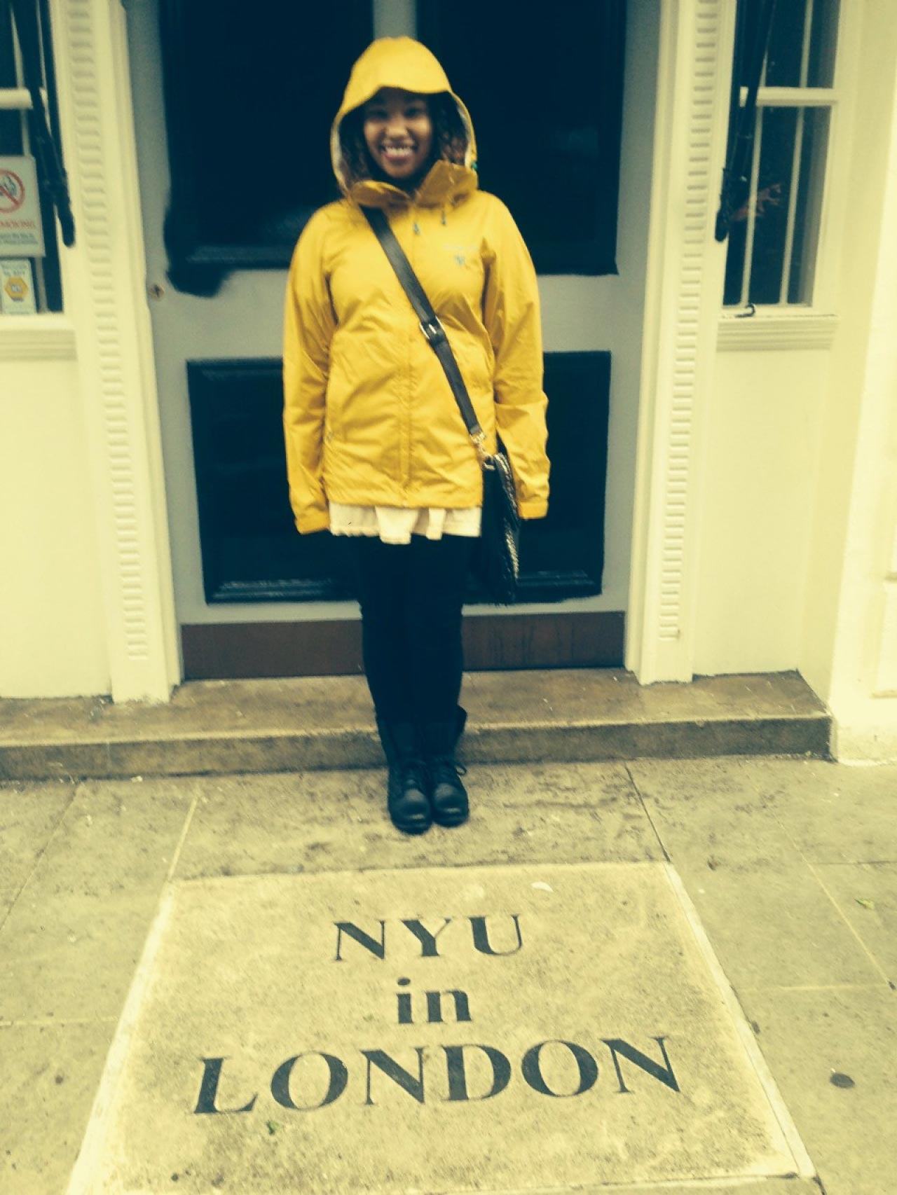 Taylor standing in front of the NYU in London sign