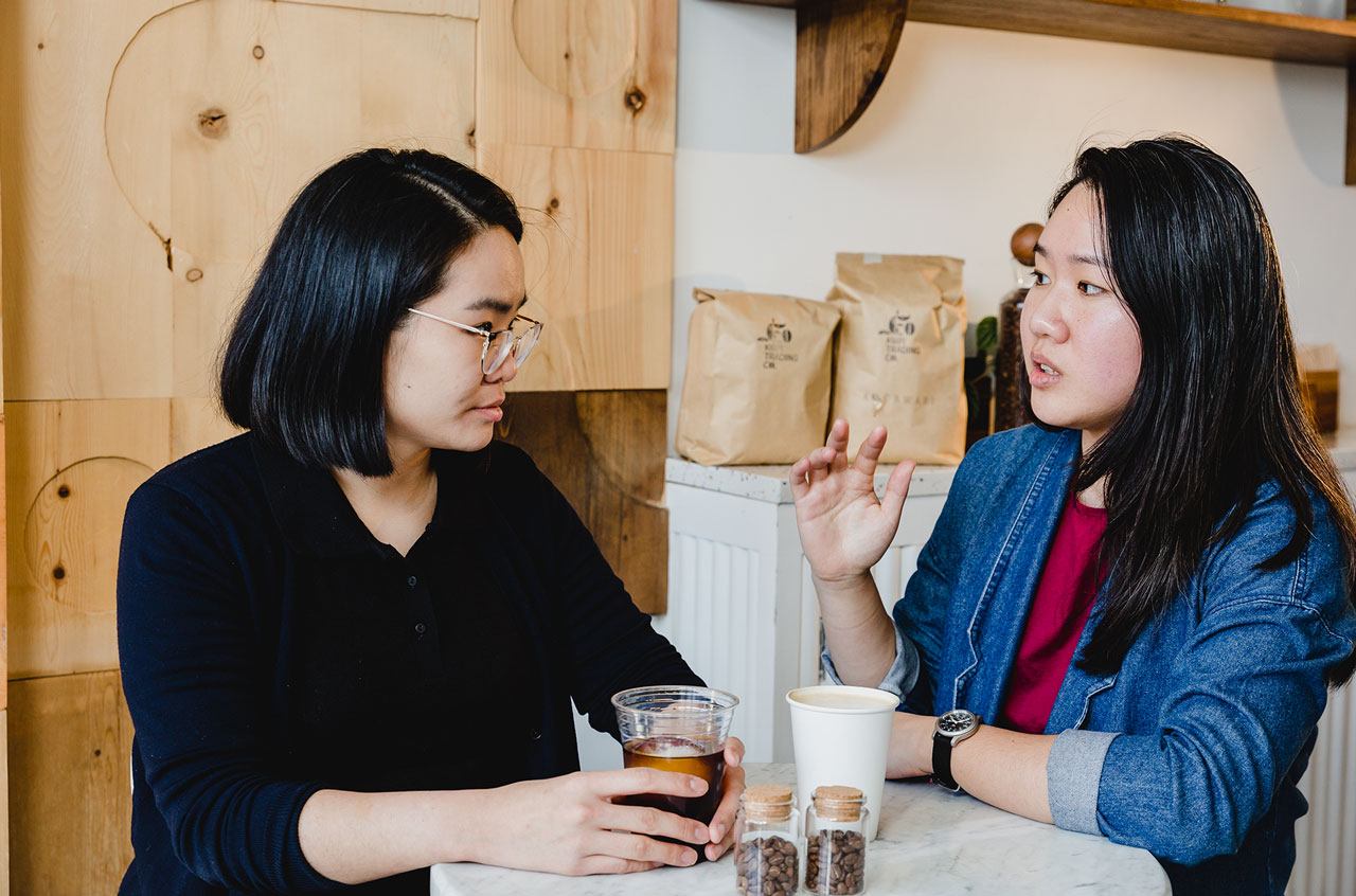 [Jessie Hsia and Hannah Lee discuss their cold brew company over a cup of coffee.]