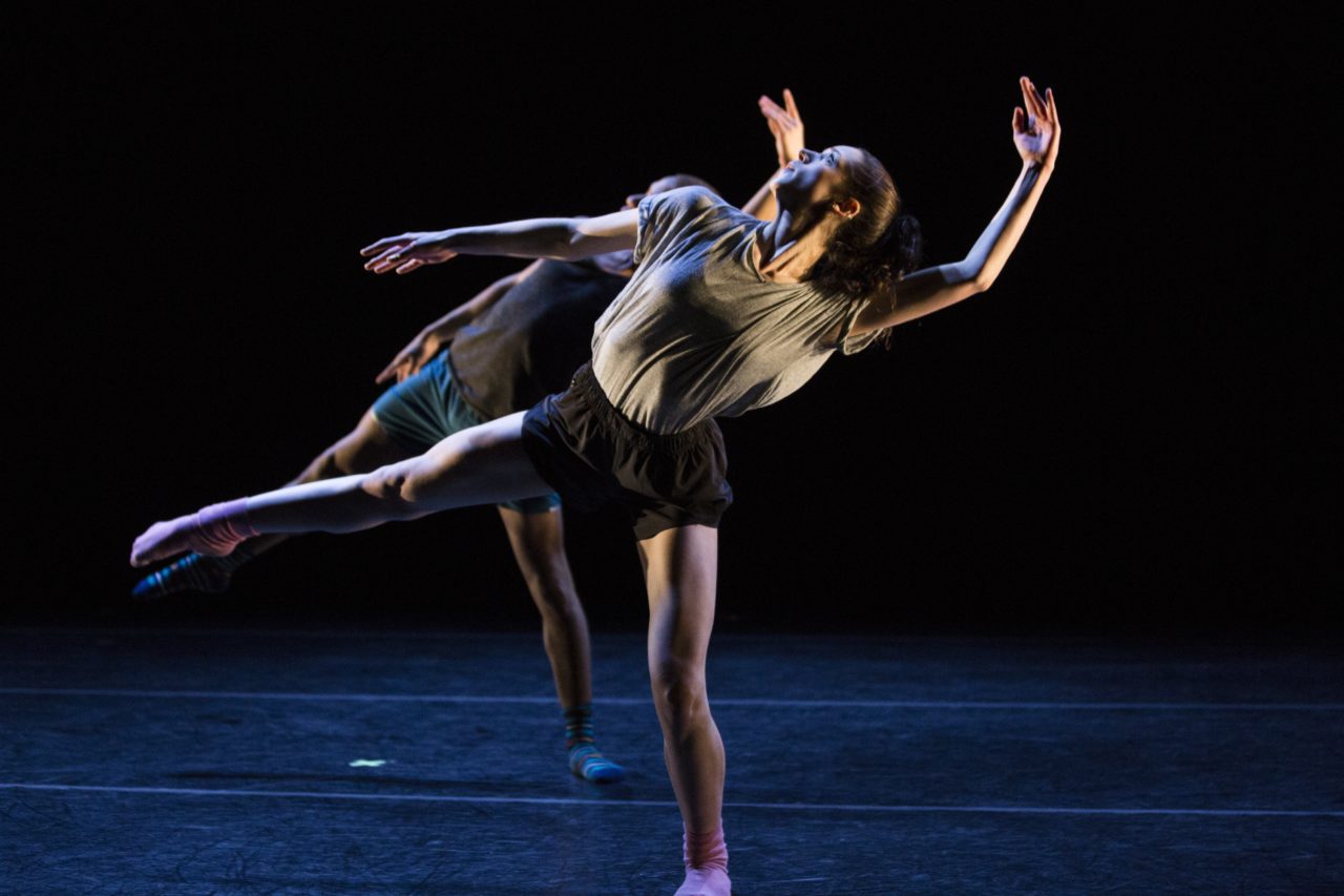 Two students performing modern dance onstage.