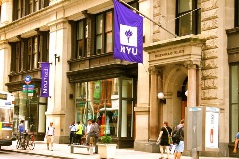 NYU Tisch School of the Arts main building decorated with NYU flags.
