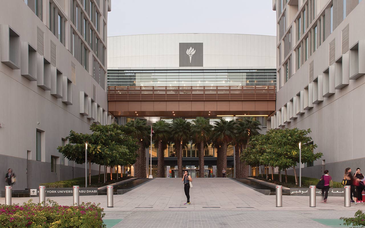 A student standing in front of the NYU Abu Dhabi campus.