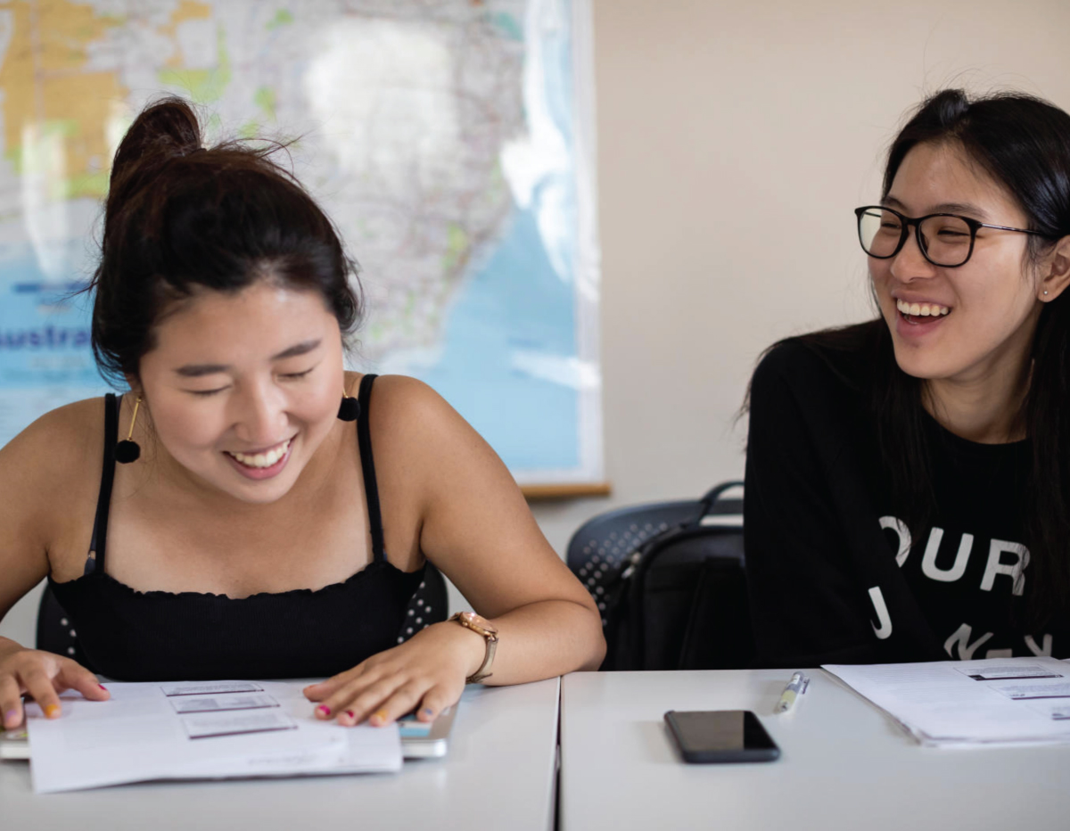Two female founders laughing in class.