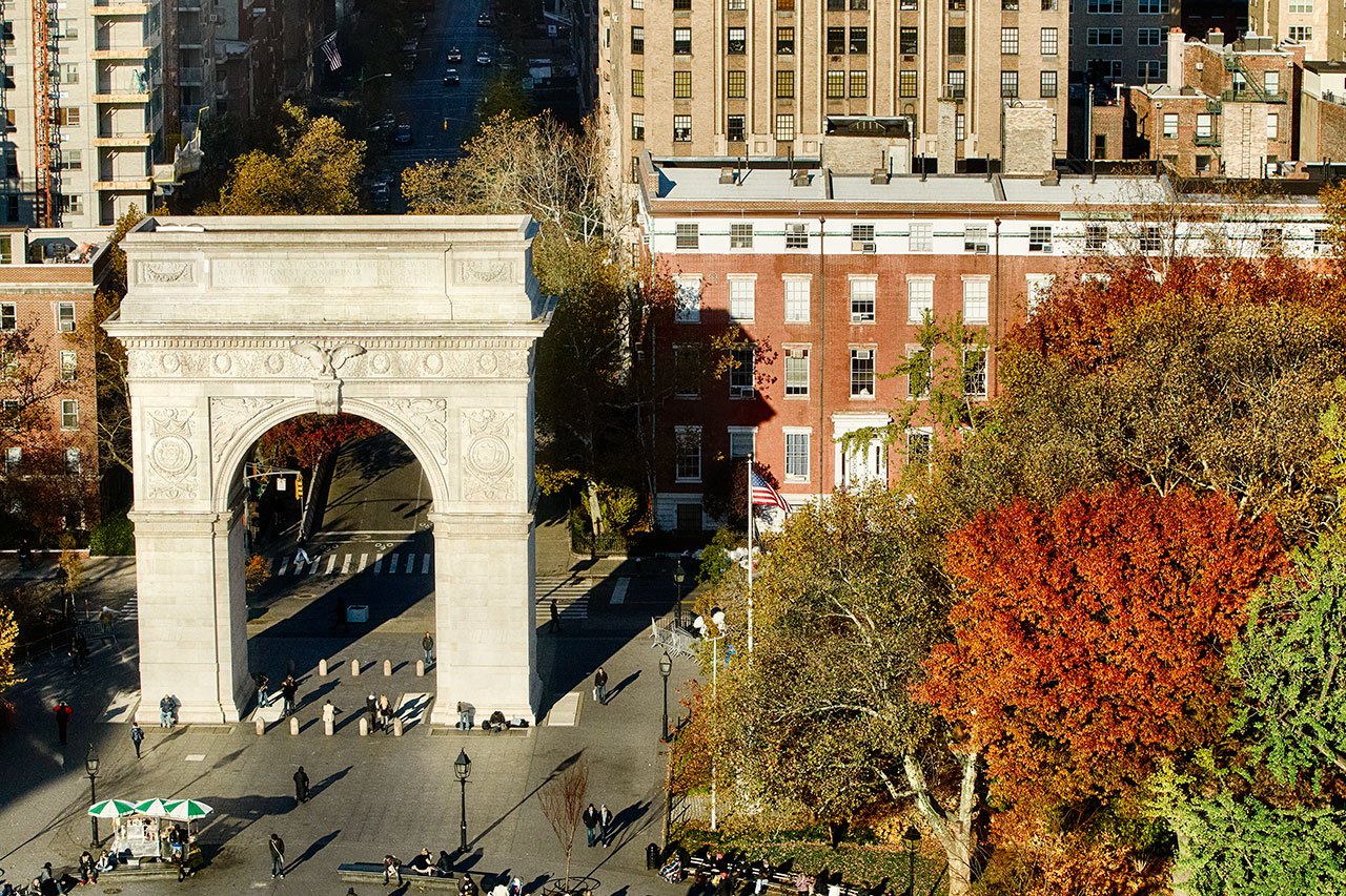 A bird's eye view of Washington Square Park, showcasing fall foliage and the arch.