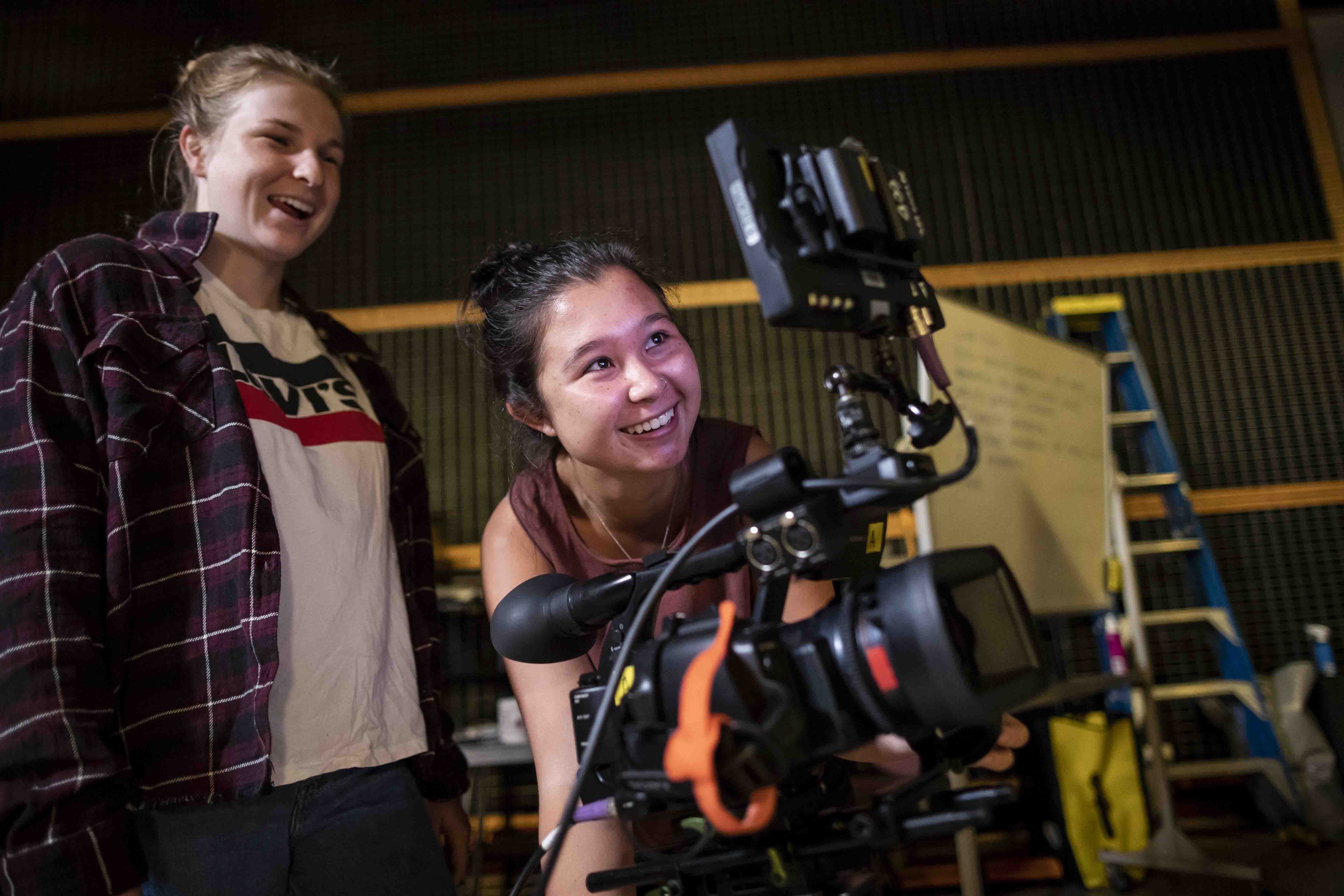 Two female students looking through a viewfinder.