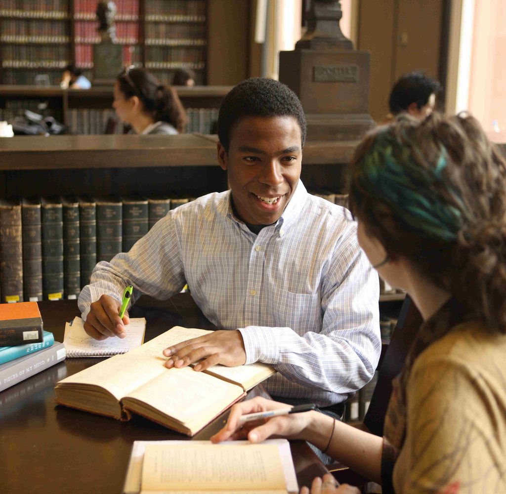 Students discussing texts in a library.