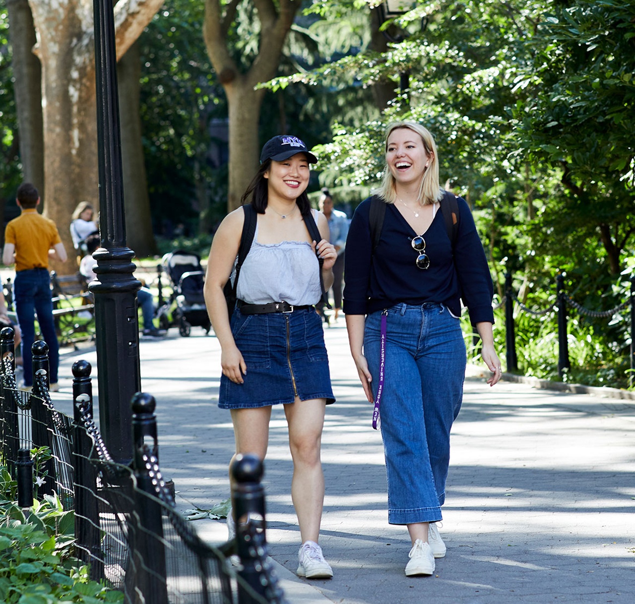 Two students walking in Washington Square Park.
