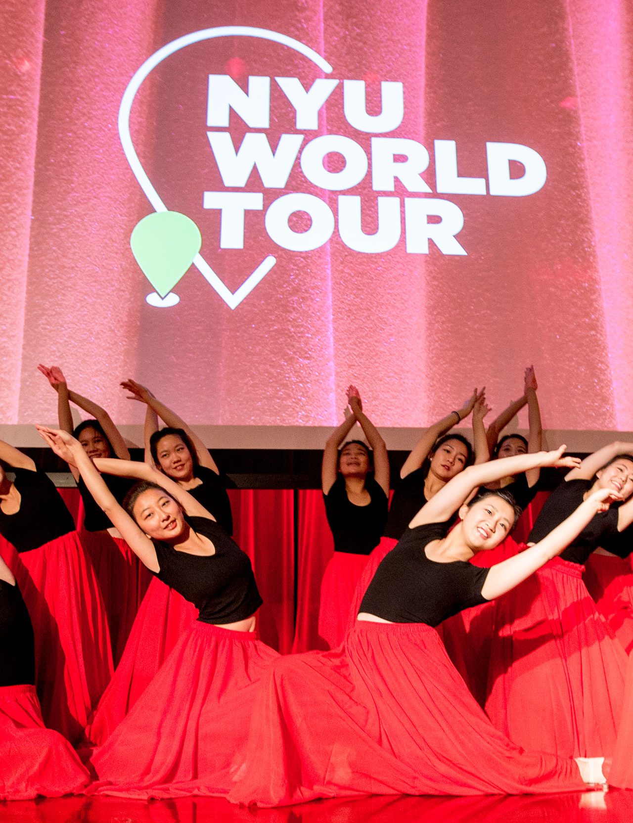 A group of students performing a choreographed dance on stage.