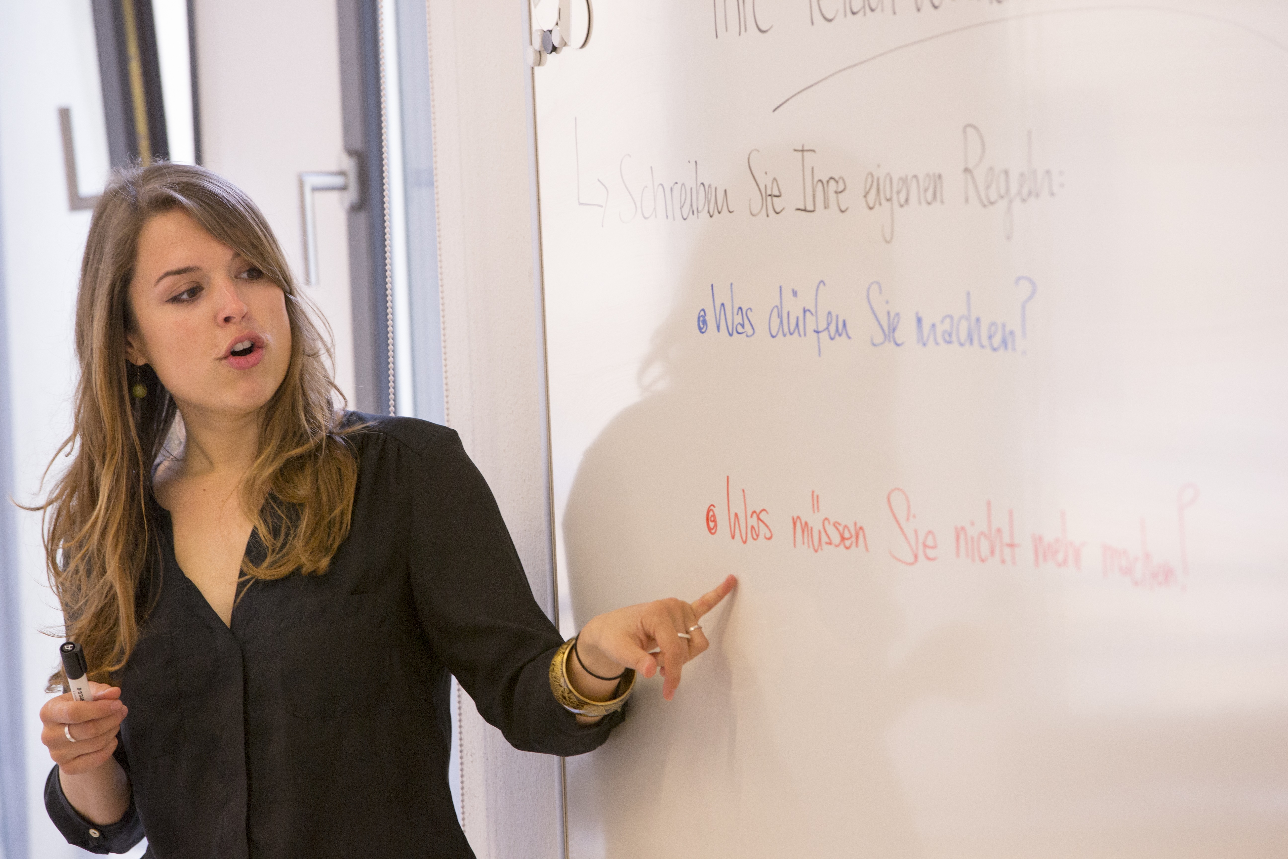 A foreign language teacher lecturing at a whiteboard.