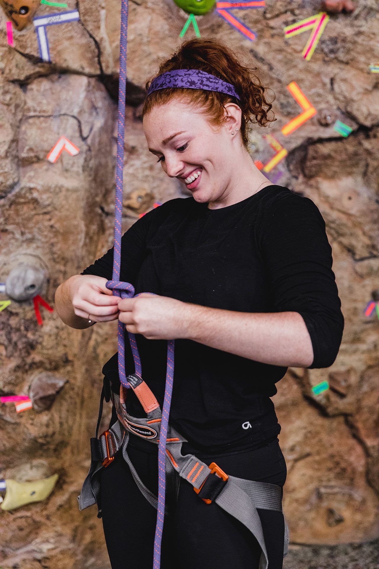 Student tying a knot for rock climbing harness.