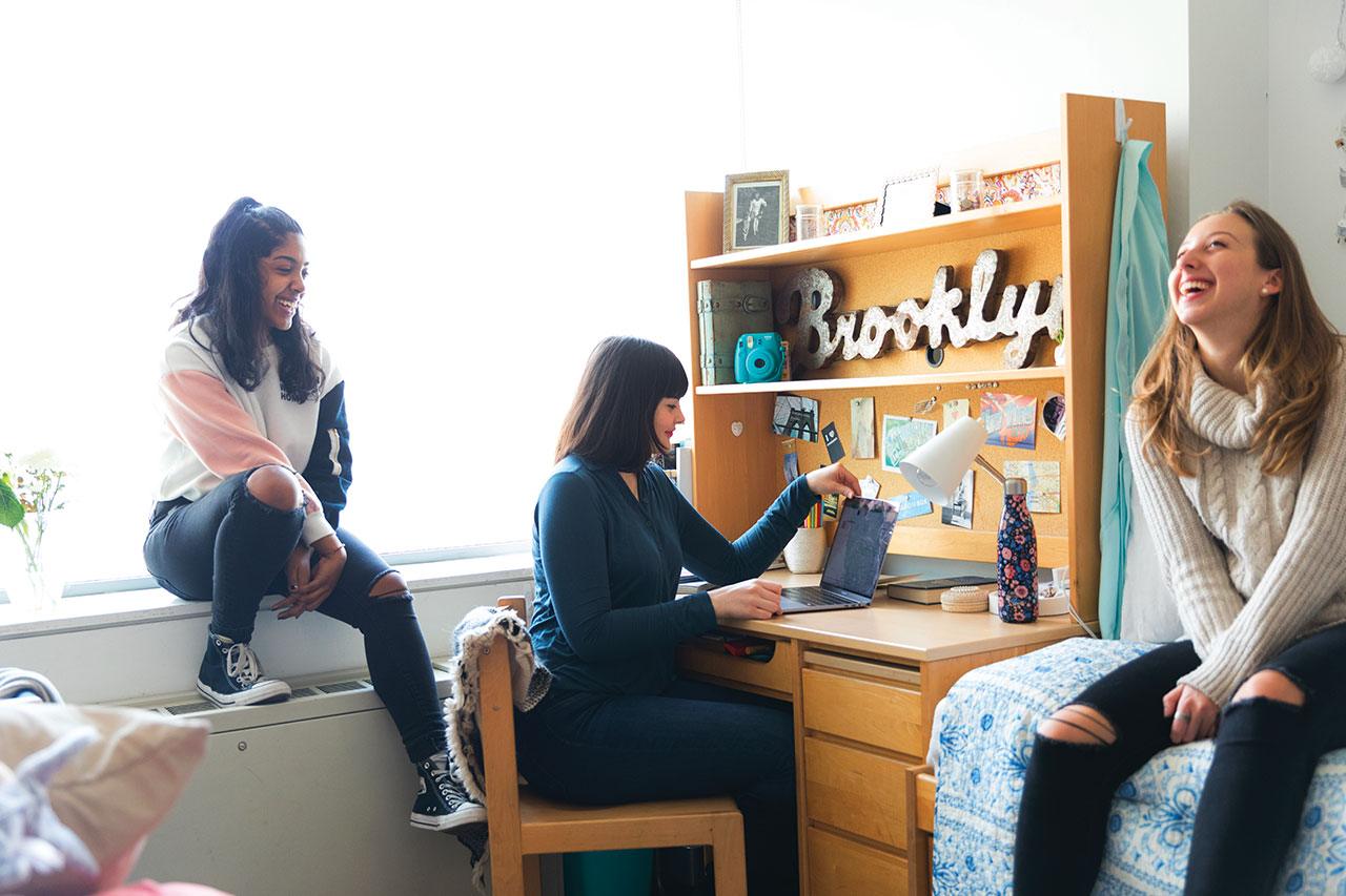 A group of students hanging out in a dorm room.