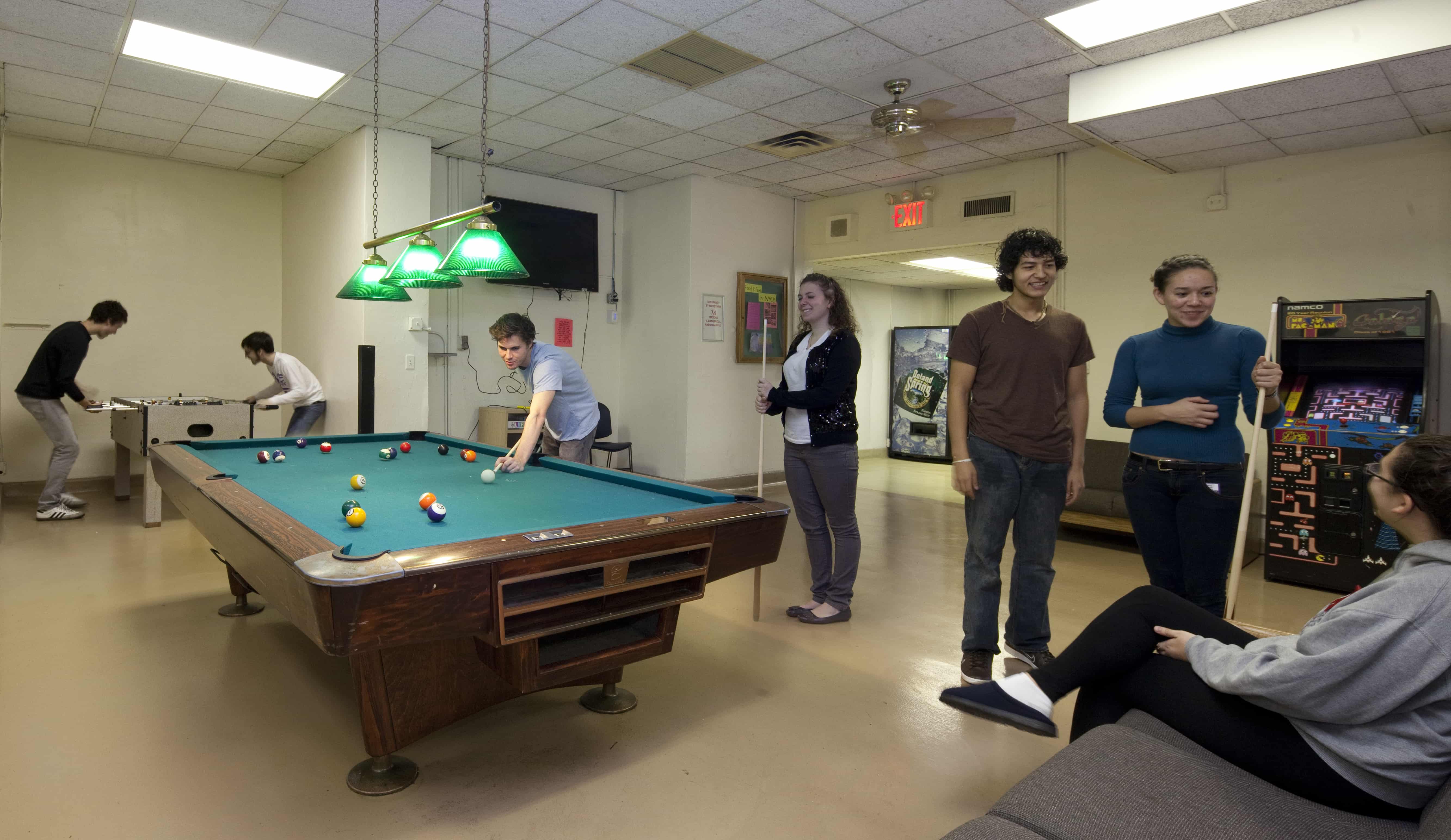 Students playing pool in residence hall lounge
