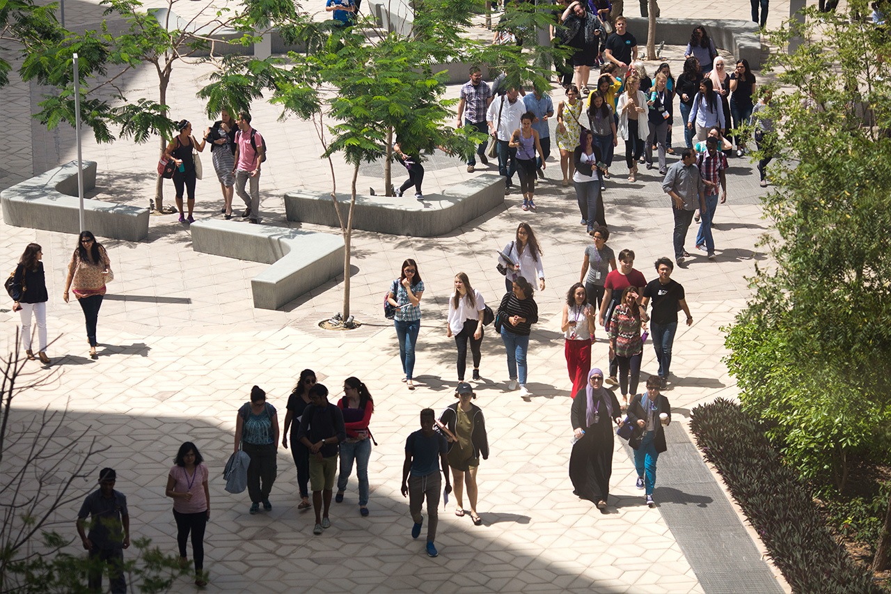 An overhead view of a large group of students walking on NYU Abu Dhabi campus.