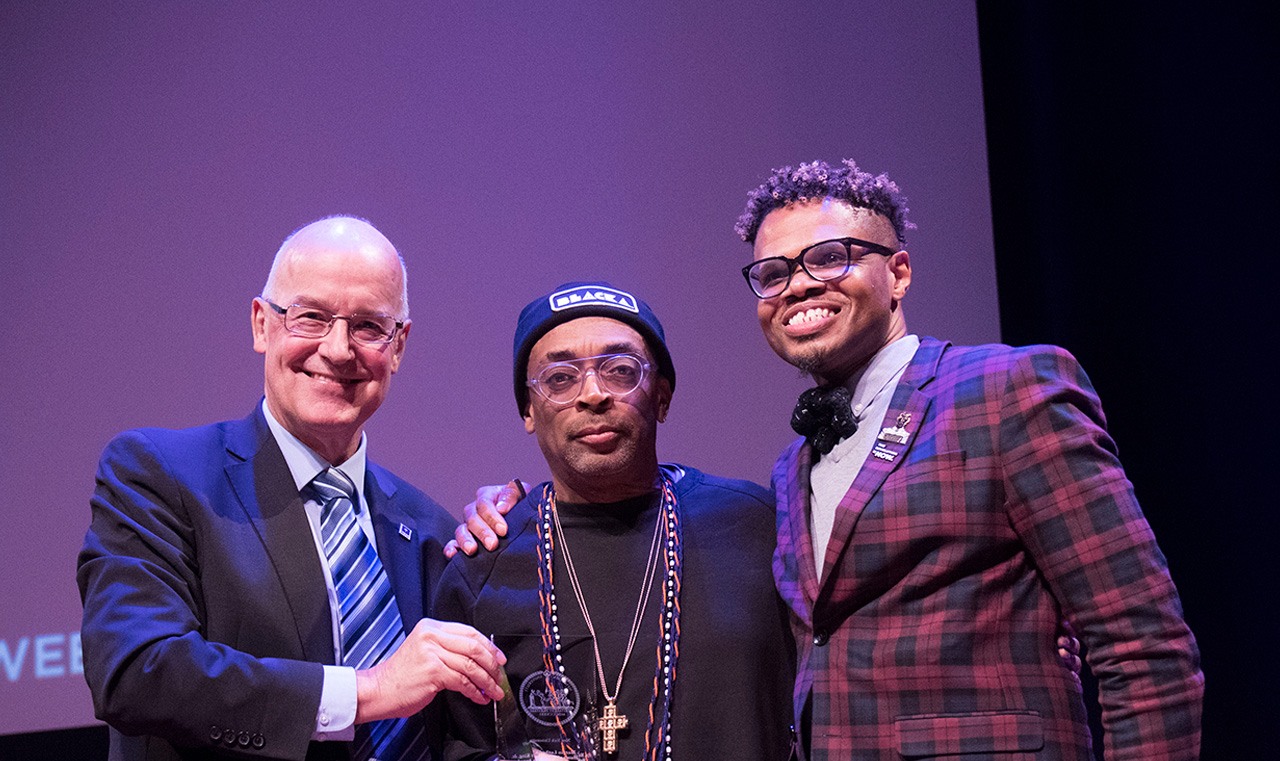 NYU President Andy Hamilton, filmmaker Spike Lee, and associate VP for global student engagement and Iinclusive leadership Monroe France posing for a photo.