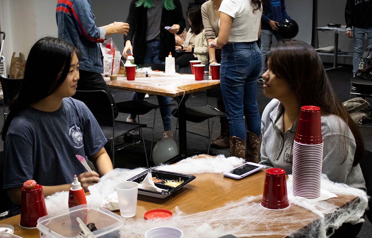 Two students seated at a table, talking to one another at a STEMinist event.
