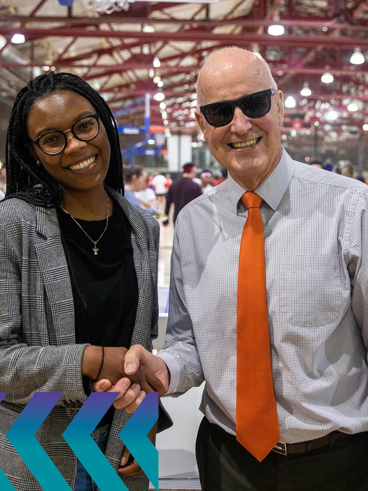 Jakiyah shaking hands with NYU President Andy Hamilton at an event.