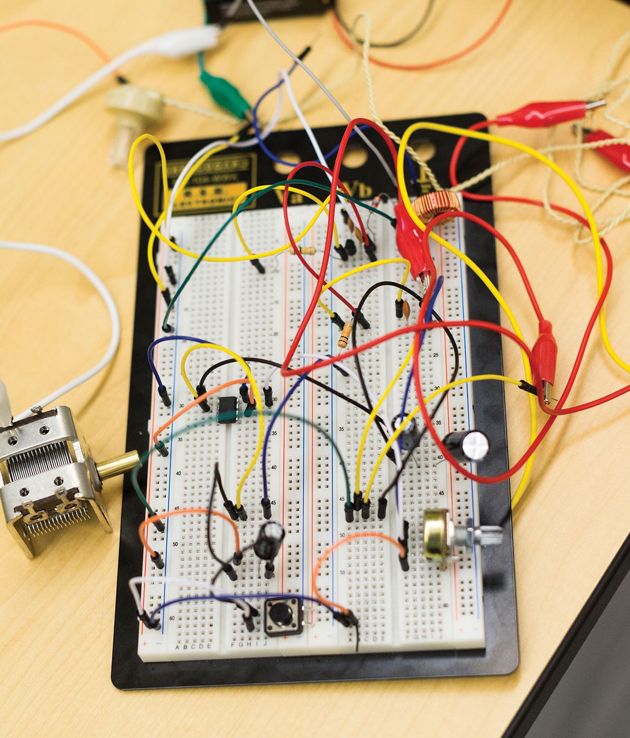 A prototyping boarding sitting on a table with many wires connected to it.