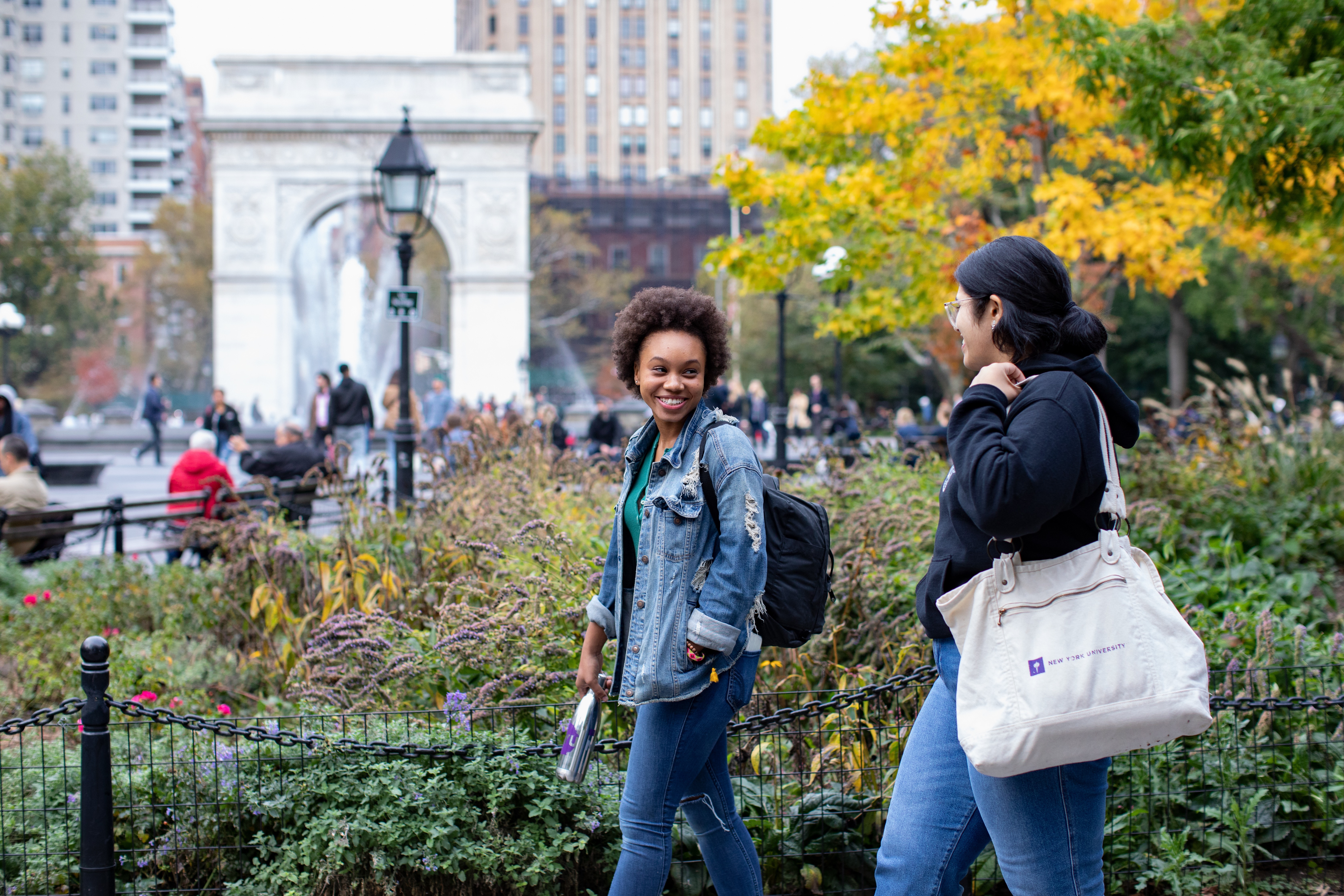 Two NYU students walking in Washington Square Park.