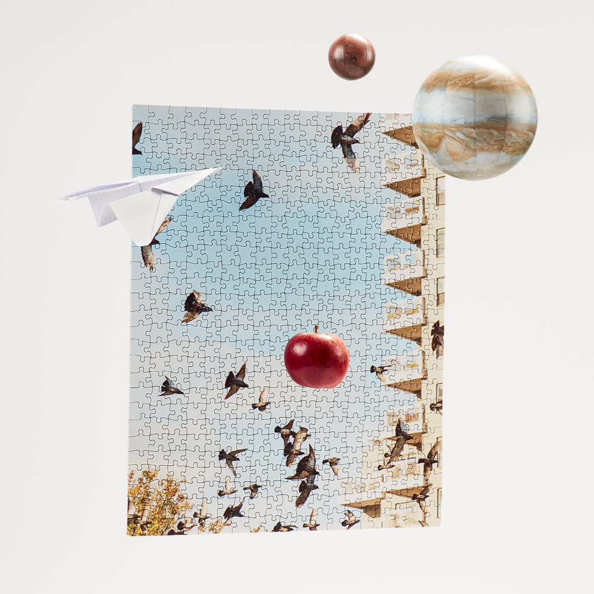 Still life of paper airplane flying towards floating plants and a falling apple against a puzzle backdrop of the sky.