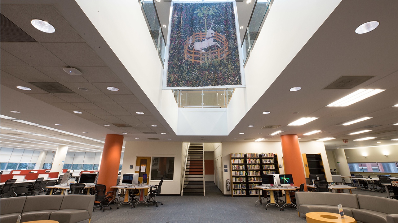 Interior shot of Dibner showing study spaces and a large tapestry hanging from the ceiling