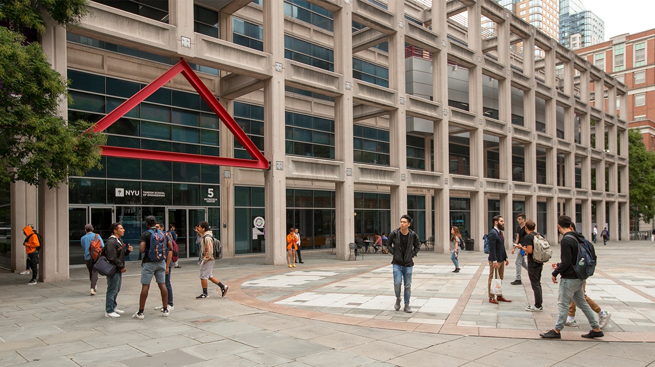 An exterior shot of Dibner with students standing near the entrance