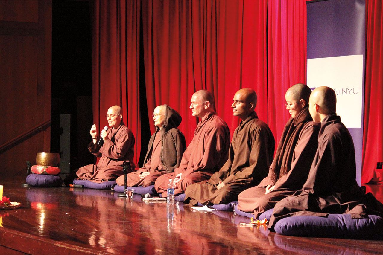 A group of monks seated on stage.
