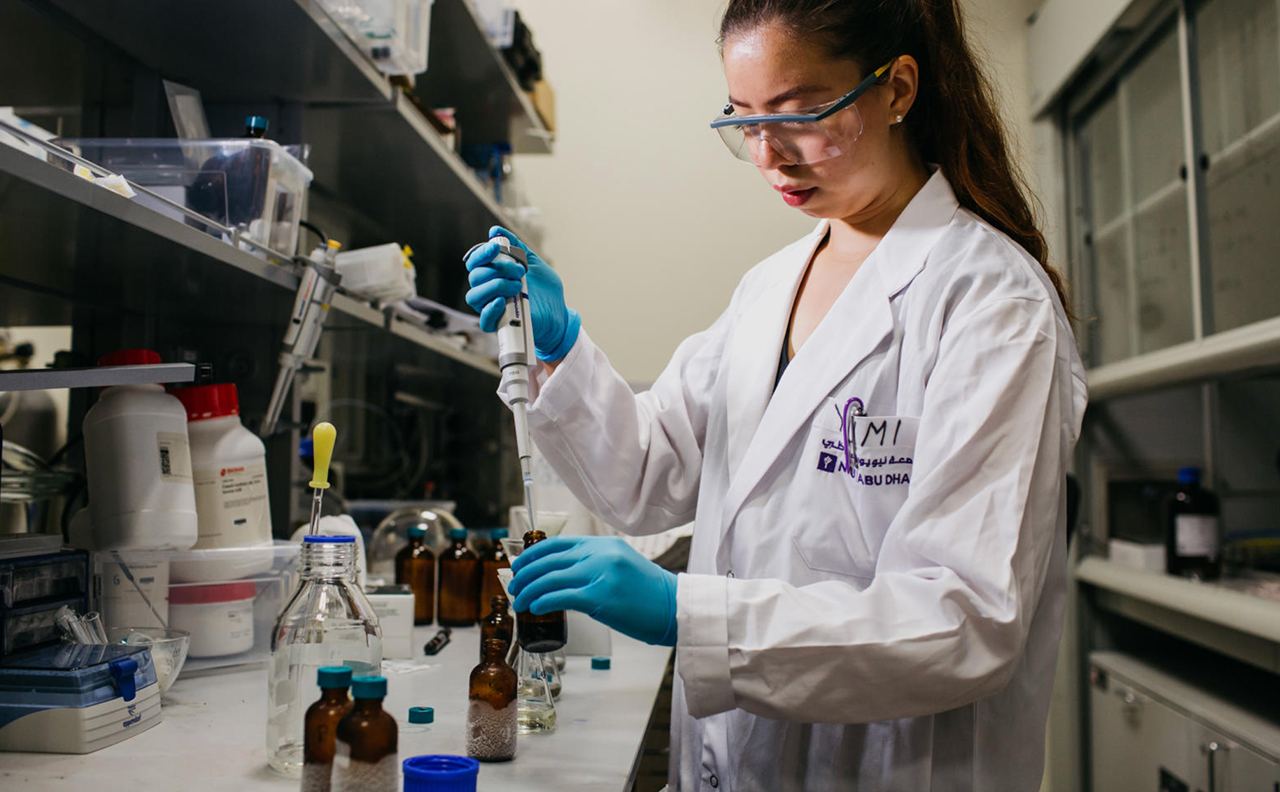 A female-resenting student of color conducting research in an experimental laboratory at NYU Abu Dhabi.