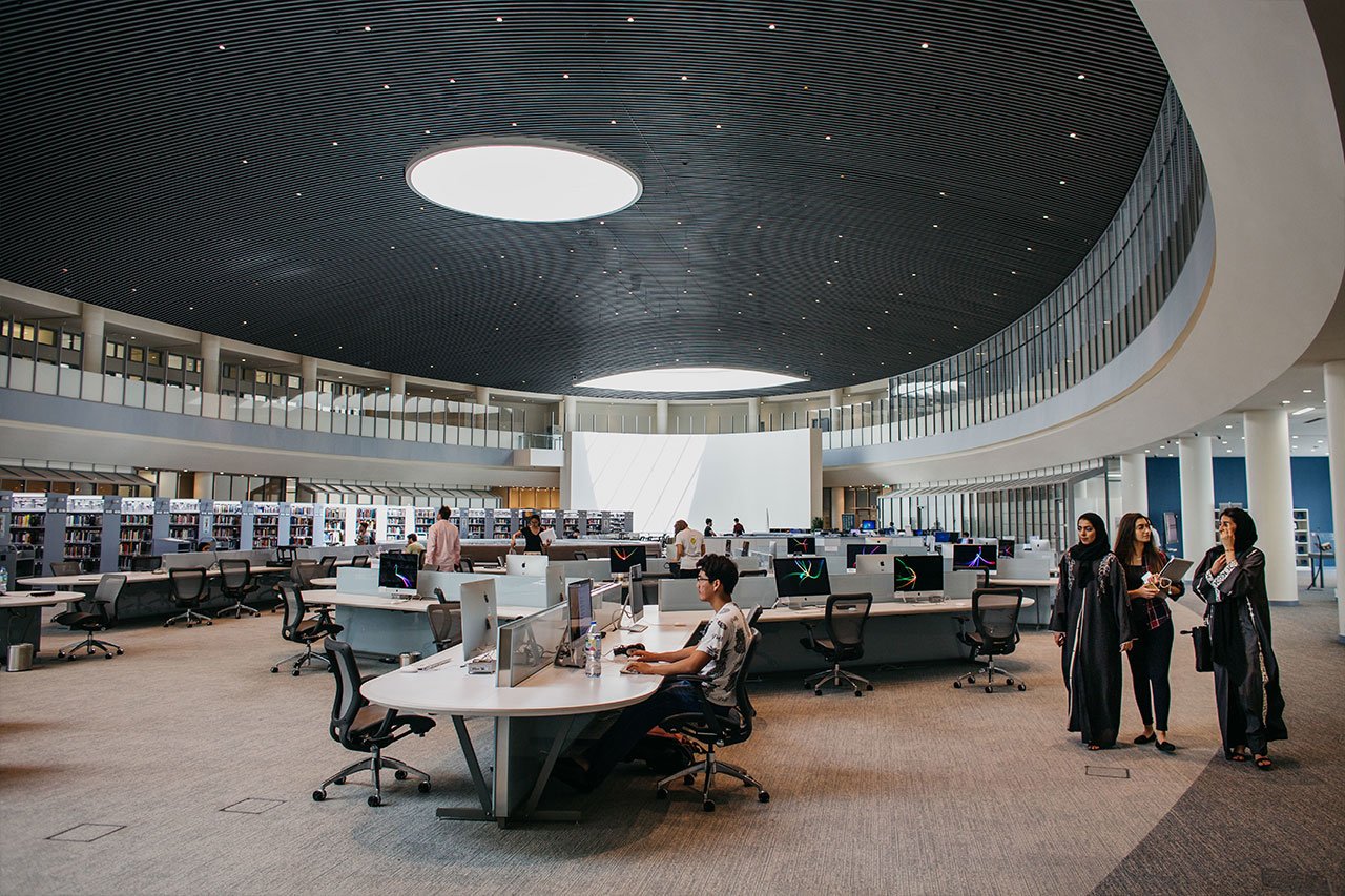 View of NYU Abu Dhabi's library with students working and studying in it.