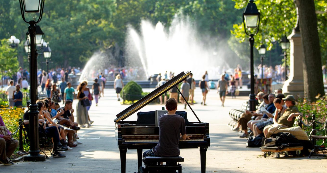 A man plays the piano in Washington Square Park