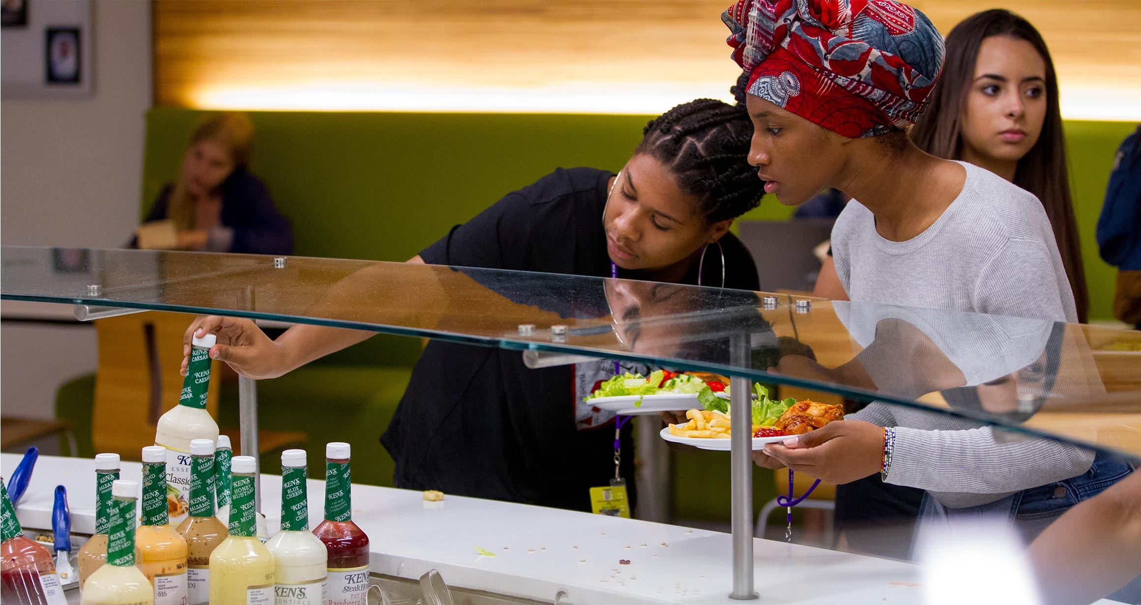 Two students grab some food from the salad bar in the Weinstein Dining Hall