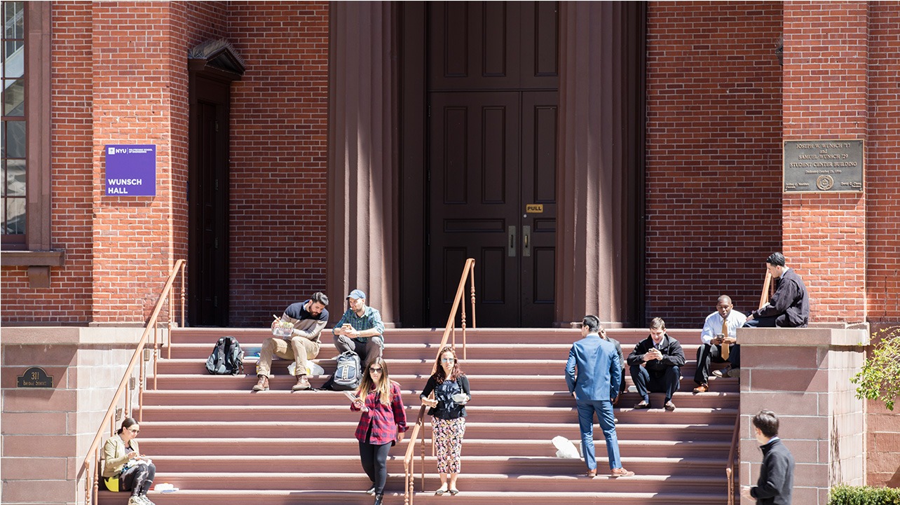 People sit on the stairs of the Wunsch Building.