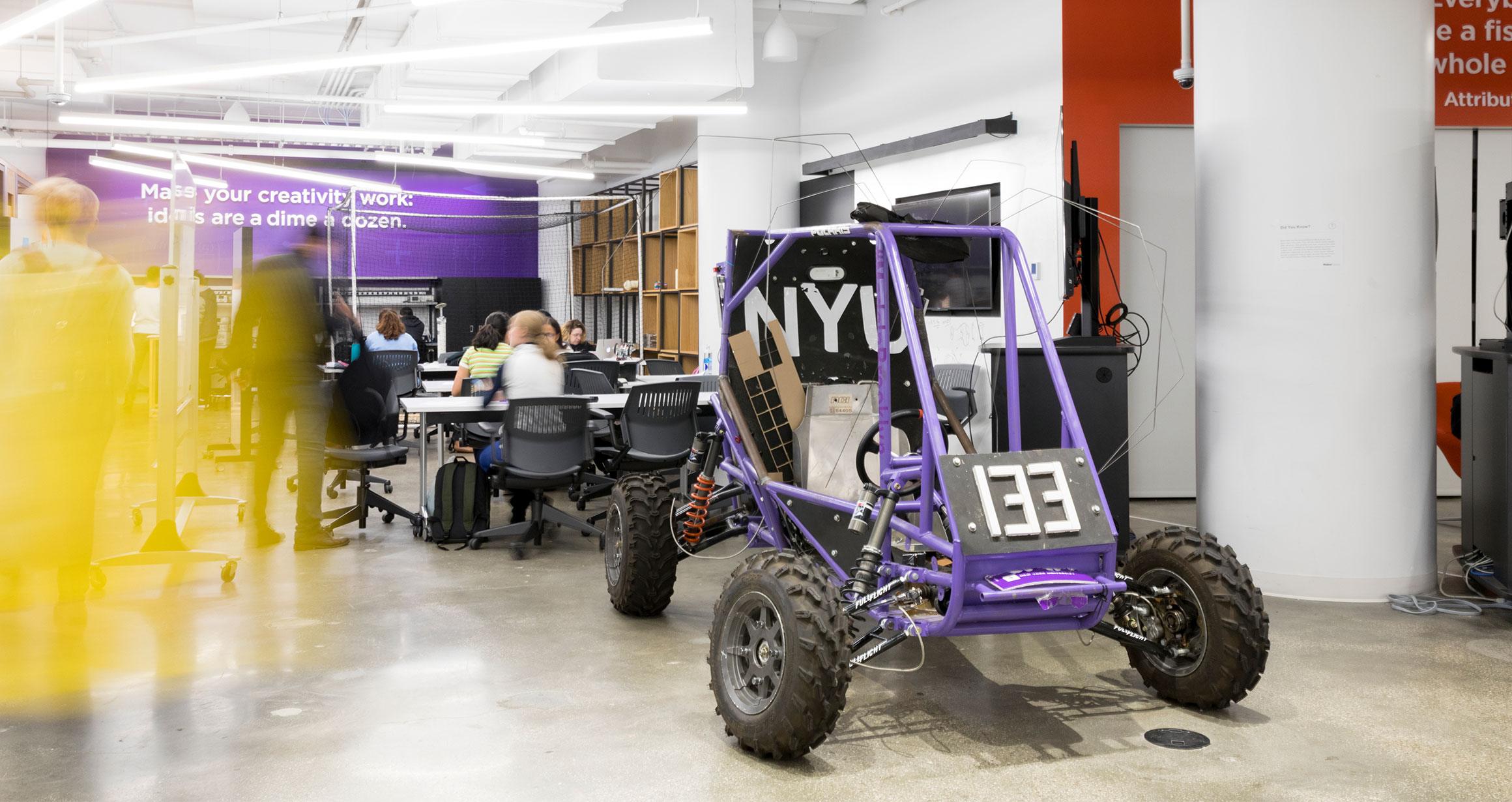 a large NYU branded go kart sits in the MakerSpace