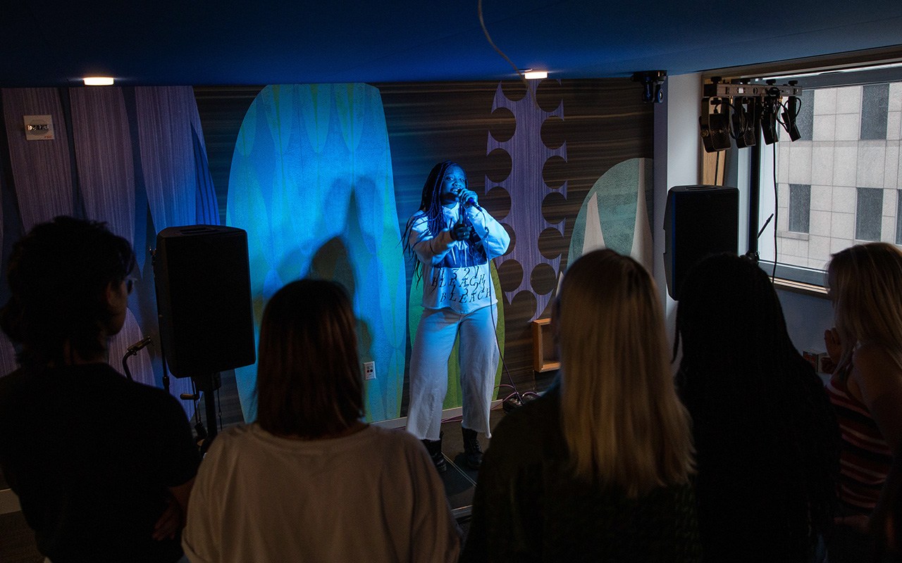 A singer performing in front of an audience at a performance space at 370 Jay Street.