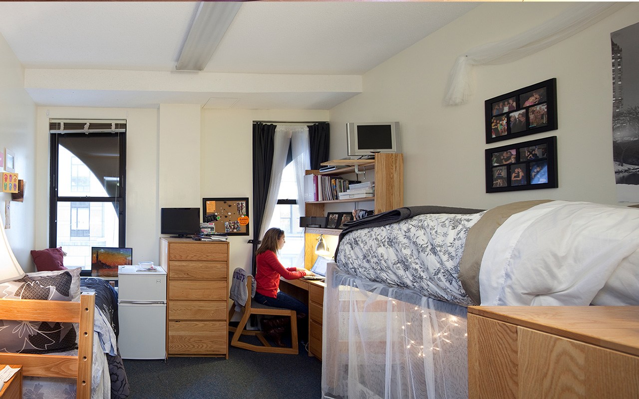 Student working at her desk in her dorm room at Goddard Hall.