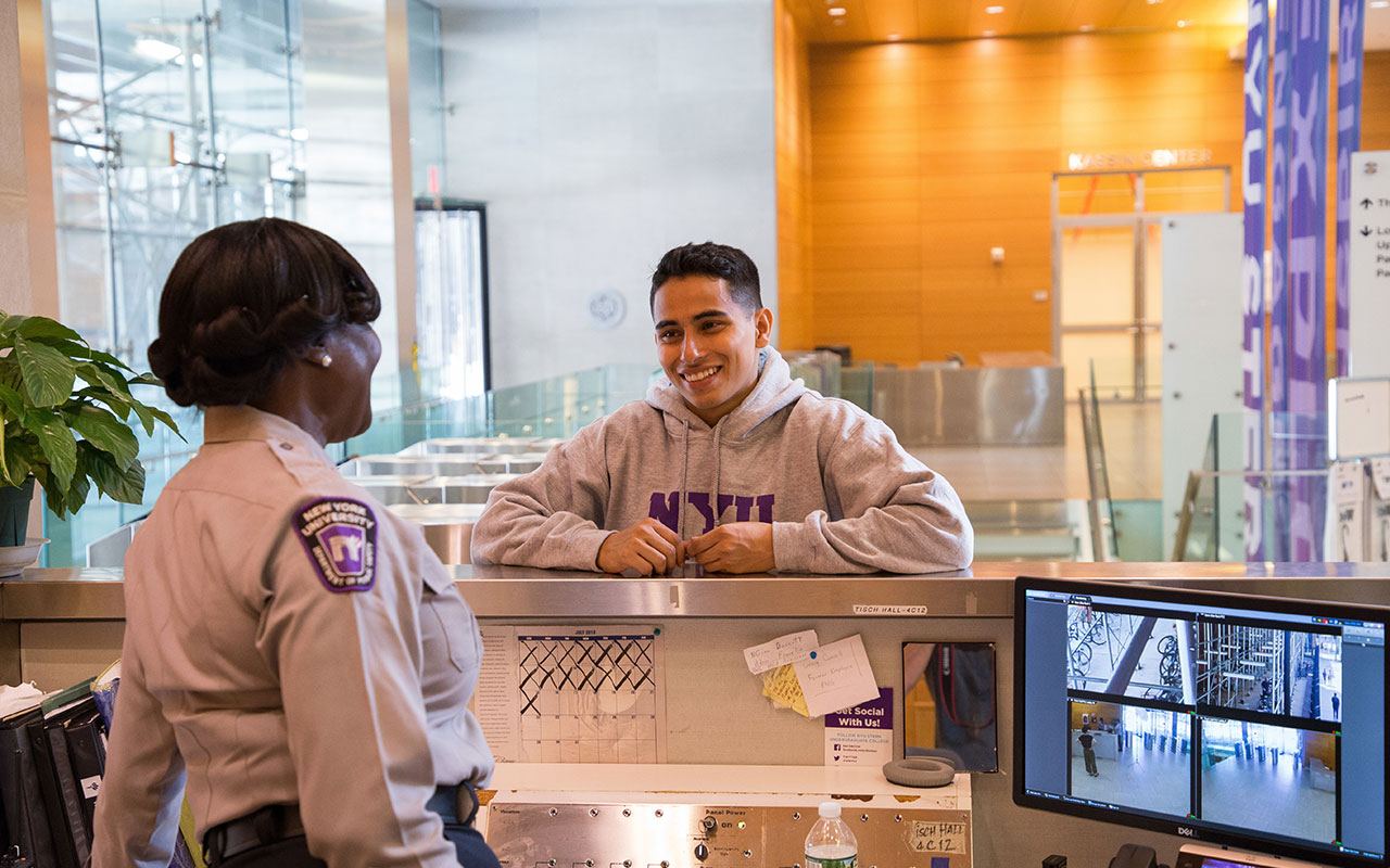 Student speaking with a Public Safety officer stationed at the front desk