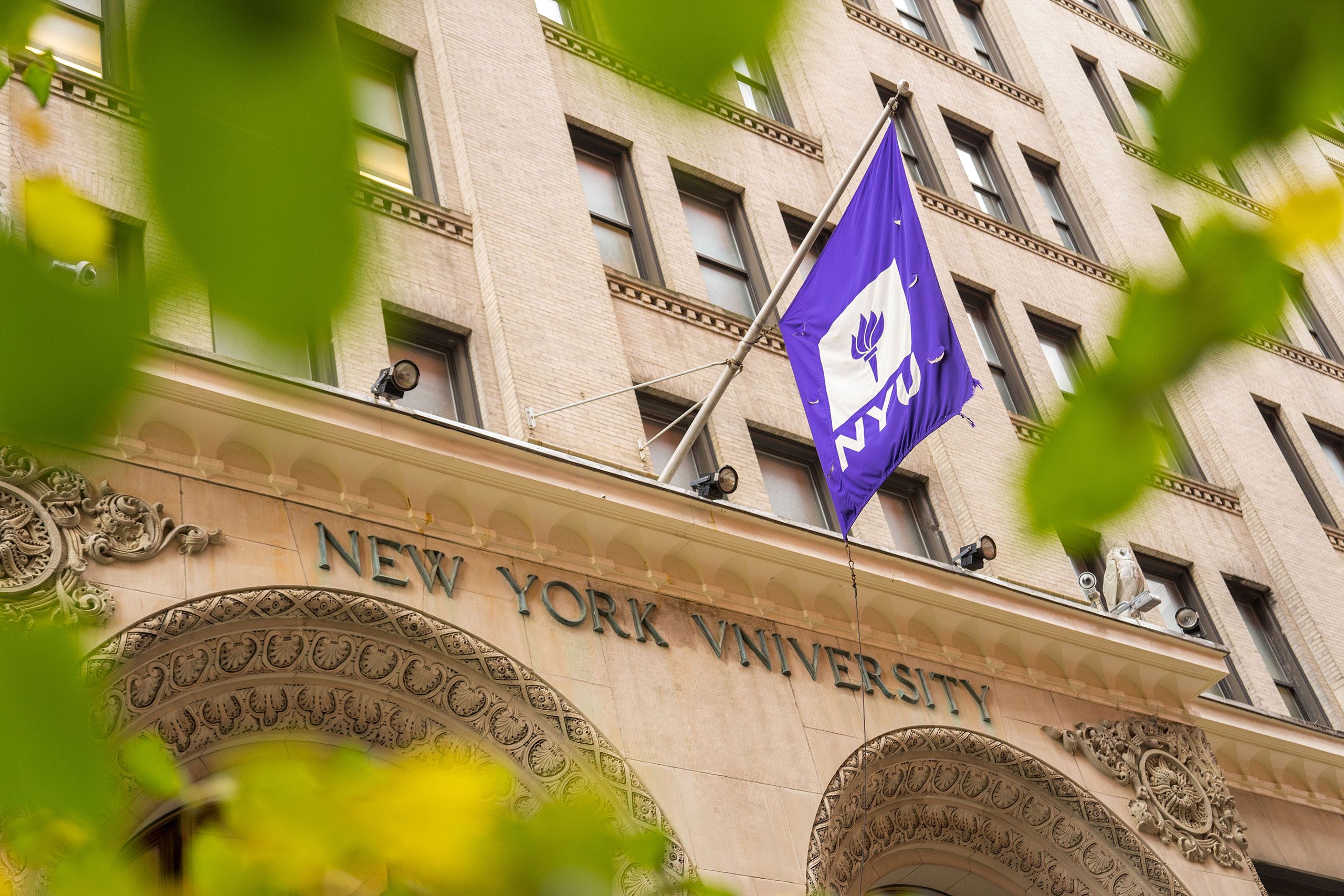 NYU flag hanging from a university building.