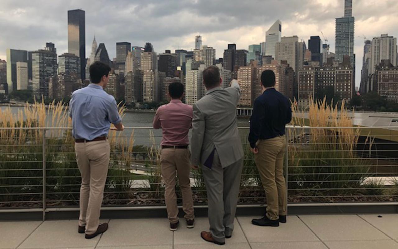 Real Estate students standing on roof and looking out onto NYC skyline