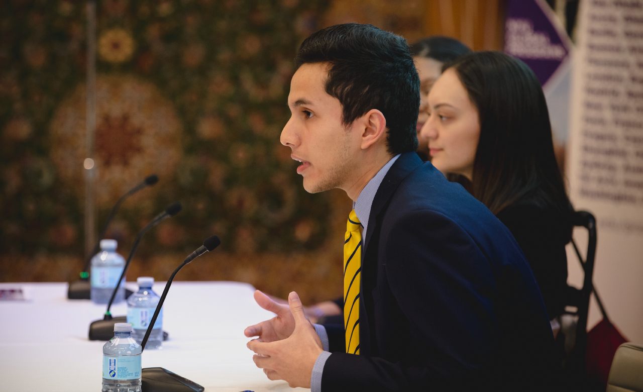 A student speaking at a panel with others.
