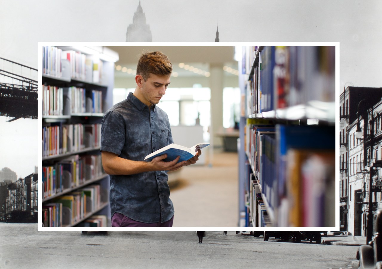 A student looking at books in a library.