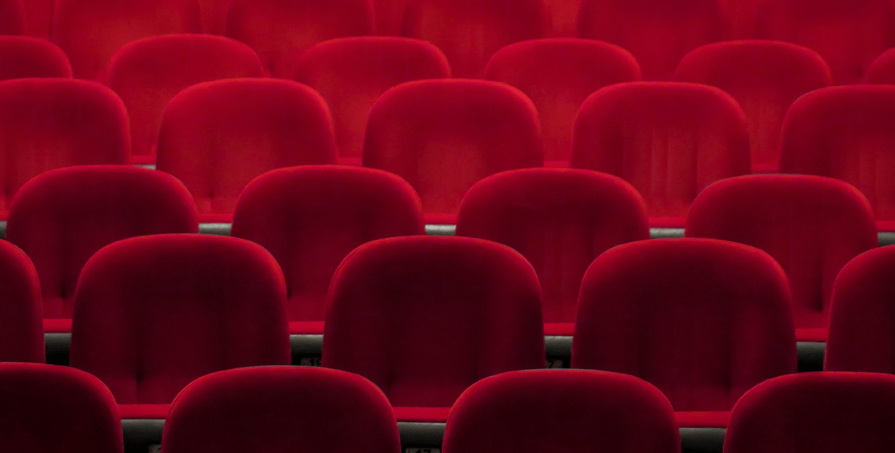 Rows of red chairs at a theatre.