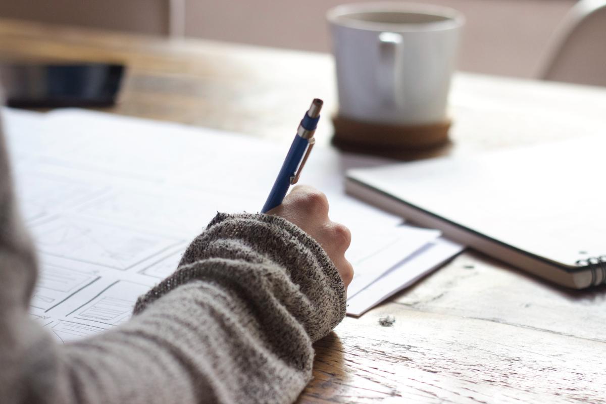 A close up of someone taking notes at a table