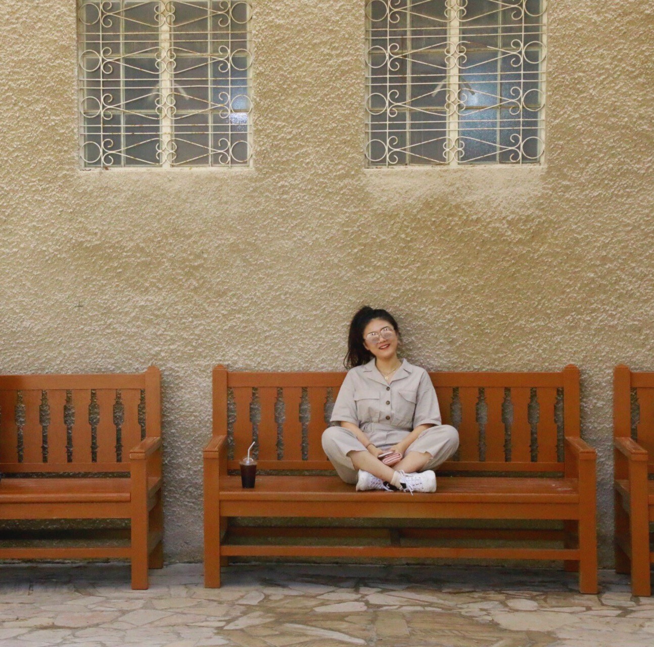 Creative Writing minor Yixuan Cui sitting on a bench, smiling.