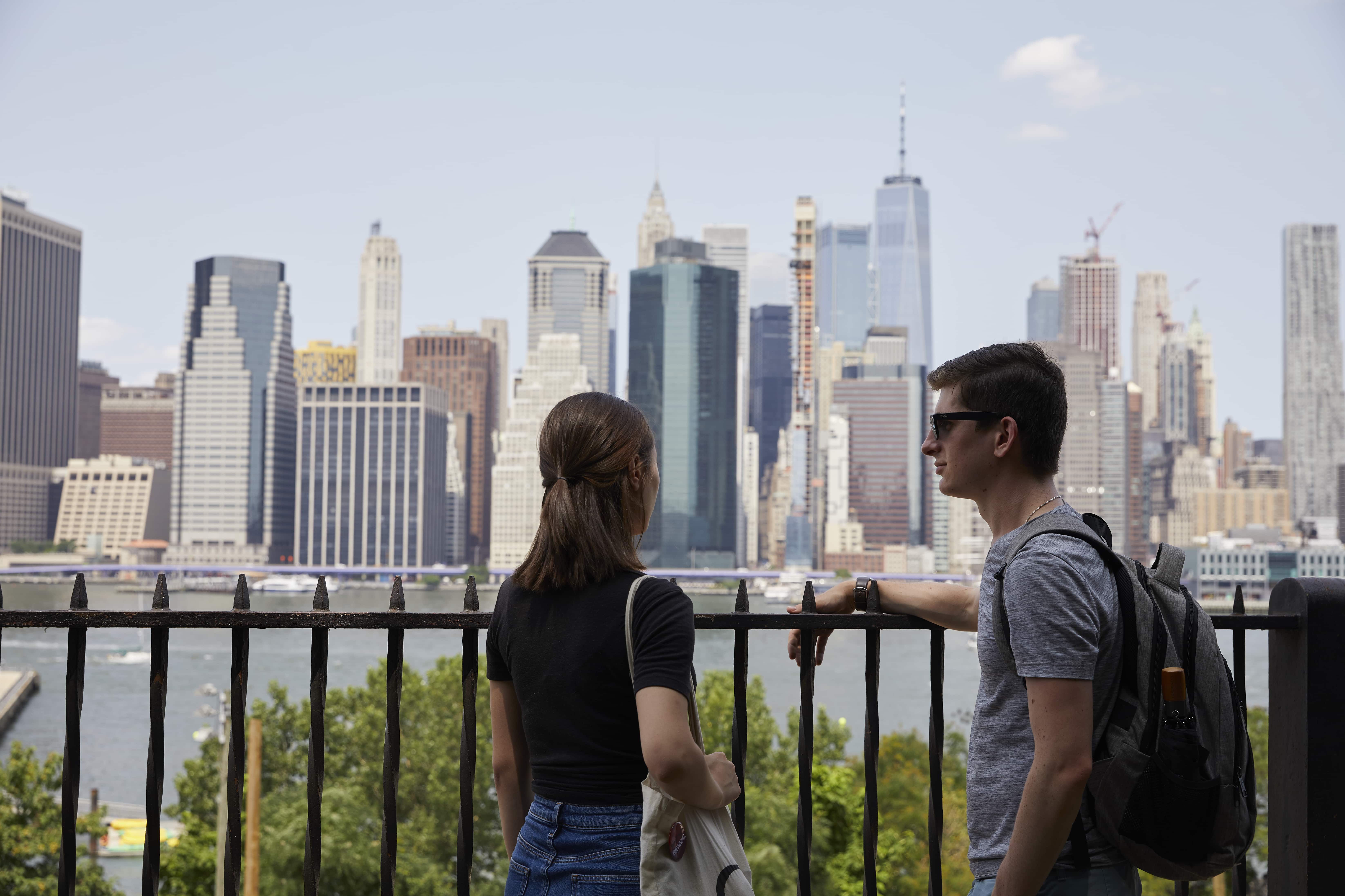 Two students looking at the Manhattan skyline from Brooklyn