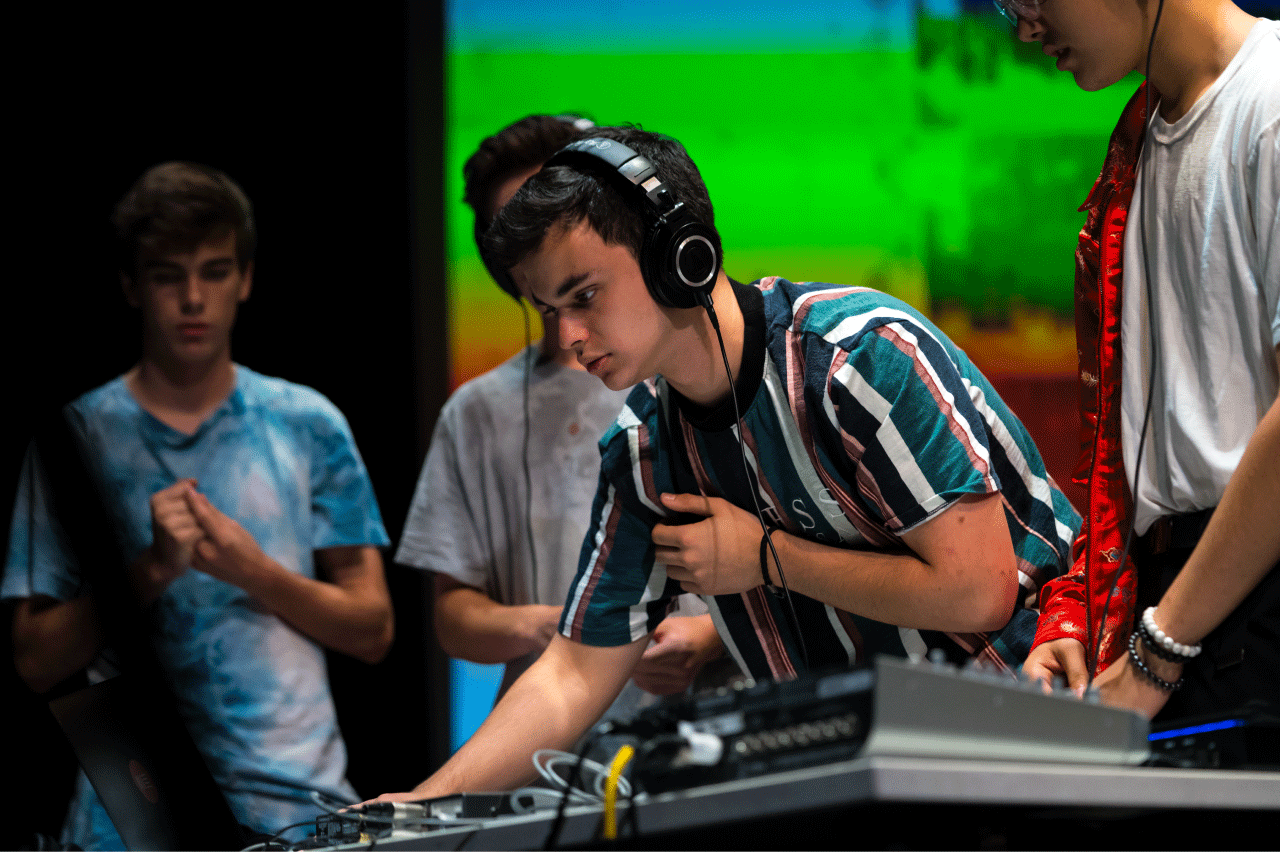 Students working onstage with DJ equipment